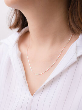 Silver necklace on a lady's neck.