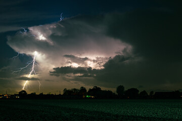 Branched positive lightning bolt strikes down from the top of the thunderstorm, outside the storm...