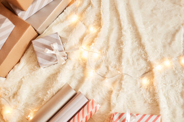 Top view of present boxes for winter holidays and wrapping paper for packing gifts on white soft carpet on floor, Merry Christmas and happy new year.