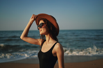 Obraz na płótnie Canvas pretty woman in hat walking on the beach ocean travel