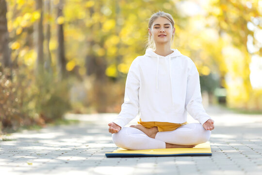 Woman practices yoga in the park. Girl in sports. High quality photo