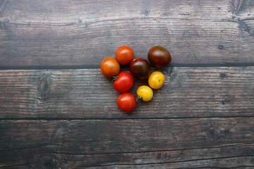 Naklejka na ściany i meble colorful tomatoes on wooden background