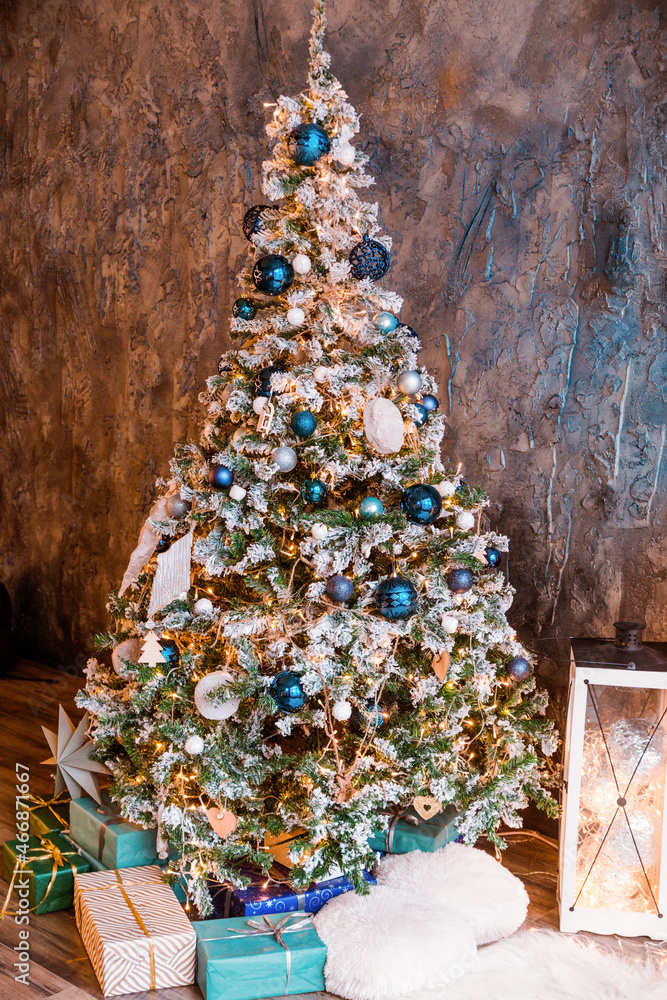 Wall mural A Christmas tree with silver and blue balloons with gifts under it stands in the living room with blue walls