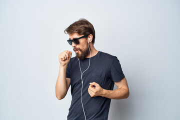 handsome man in a black t-shirt music in headphones movement light background