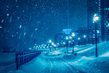 Night blizzard Humidity in big city. Street lamp outdoor light under falling snow. Christmas night...