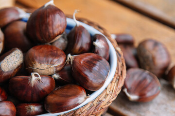 basket full of fresh chestnuts on wooden background