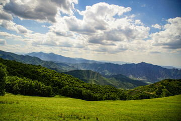 Fototapeta na wymiar Mountain slope blue sky white cloud landscape mountain forest natural scenery