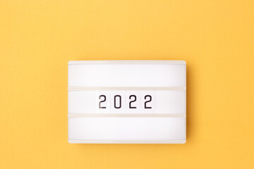 White lightbox with 2022 numbers on a golden background with copy space.