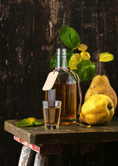 Traditional homemade quince fruits liqueur. Dark rustic style. Alcohol drink concept. Selective...