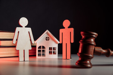 Wooden model of couple, gavel and house. Law and divorce concept