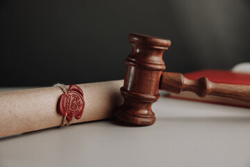 Wooden gavel and document with wax seal on a lawyer's desk close-up