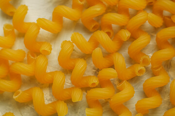 Dry raw cavatappi pasta with strips on the background. Italian food.