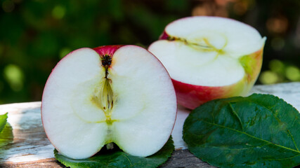 Red apple cut in half with water drops on an old table, close up, copy space, background
