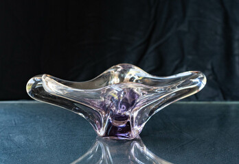 Mid-century modern artistic purple glass bowl isolated on black background