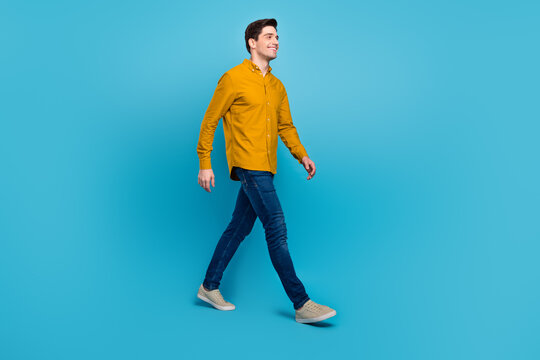 Profile photo of handsome guy enjoy stroll wear yellow shirt jeans footwear isolated blue color background