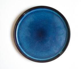 round blue handmade ceramic plate isolated on a white background
