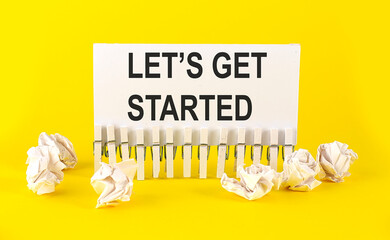 text LET'S GET STARTED on the white short note paper yellow background
