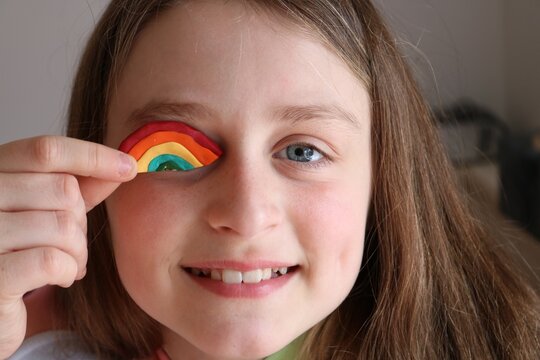 Close-up Portrait Of Smiling Girl With A Little Fimo Creation On Her Blue Eye