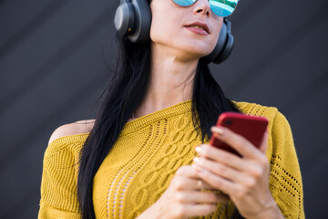 Attractive and beautiful Caucasian brunette girl in headphones listening to music in headphones and...
