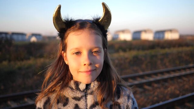 Cute kid little girl in devil horns posing face portrait