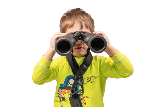 The boy looks through binoculars. Photo in the studio.