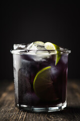 Gin based black old fashioned cocktail. Selective focus.