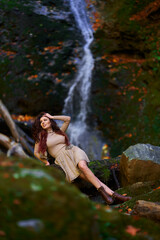 Beautiful young woman by a waterfall