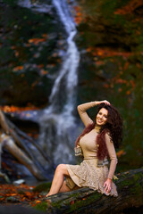 Beautiful young woman by a waterfall