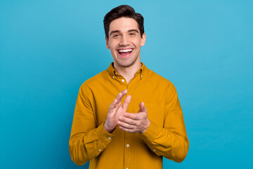 Photo of excited spectator guy applauding hands enjoy performance wear yellow shirt isolated blue...