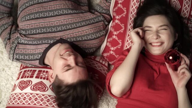 Happy couple having fun at xmas eve and lying head to head. Top view. Relationship, family, christmas, new year, holiday concet.