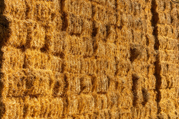 Texture of stacked straw bales in warm light