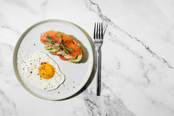 breakfast fried egg with toast with avocado and salted salmon