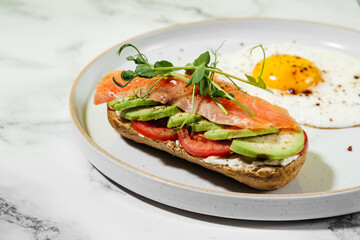 breakfast fried egg with toast with avocado and salted salmon