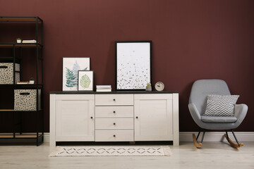 Modern room interior with chest of drawers near brown wall