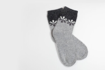Winter white with gray knitted socks with snowflakes. Top view, copy space for text