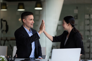 Business man and woman business hi five bump hand together for team work, diversity business team concept.