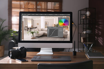 Retoucher's workplace. Computer with photo editor application, camera, smartphone and graphic tablet on table in office