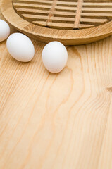 fresh white eggs on a rustic wooden chopping board background with text space