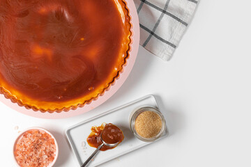 Classic cheesecake with caramel sauce on white plate on gray background. Copy space for text.