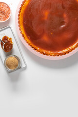Classic cheesecake with caramel sauce on white plate on gray background. Copy space for text.
