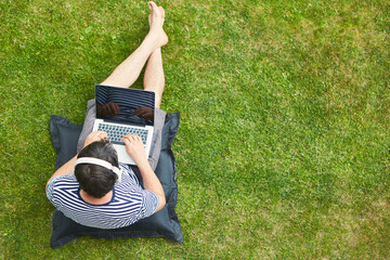 Man using laptop computer on the lawn in the garden