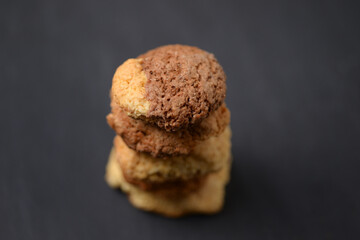 Traditional homemade coockies staked on a dark table, bokeh background. Nobody, copy space.