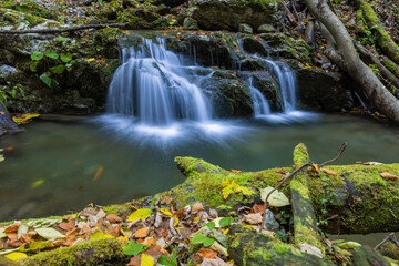 Small waterfall through the rocks covered by the moss in autumn in Zeleni vir, Croatia