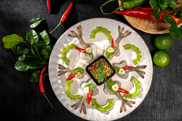 Raw Shrimp in fish sauce and many herbs. A delicious recipe from Asia and spices ingredients for cooking on dark black wooden table background, Thai food, Asian foods, Thailand restaurant menu
