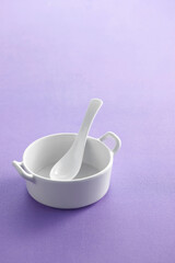 Ceramic spoon in cup on pastel background