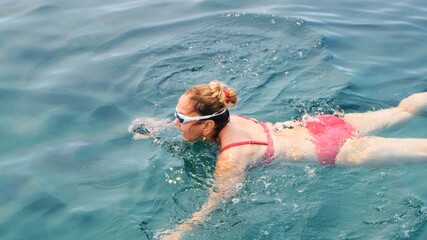 female senora in glasses is practicing crawl swimming in the sea. Professional swimmer, swimming race. Front crawl swimmer. Swimming lessons.