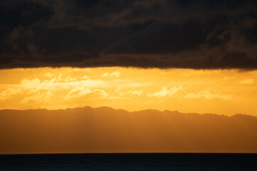 Enchanting sunrise with clouds and golden colors over the sea in Madeira
