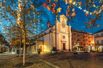 Fototapeta na wymiar Church on town square and Christmas illumination on the trees in Alba, Italy.