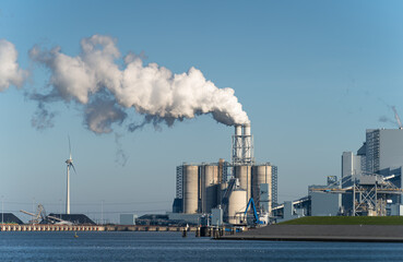 Fossil fuel (coal) power station and wind turbines in the Eemshaven generating power. Energy...