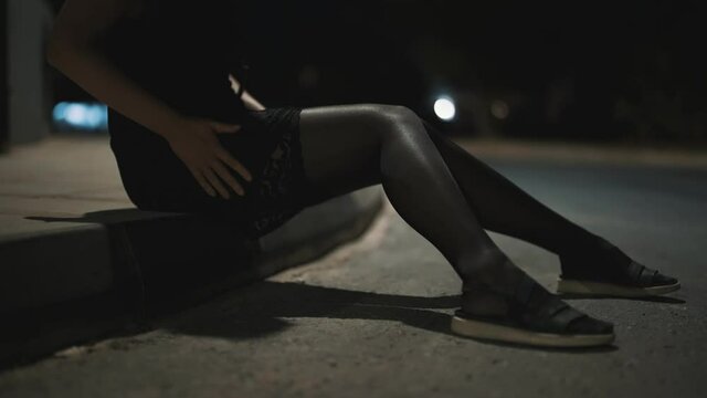 Female prostitute hiding money in stockings on the street.